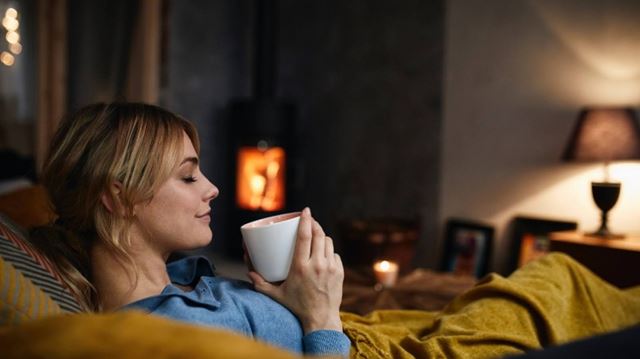 Woman relaxing on sofa with hot drink